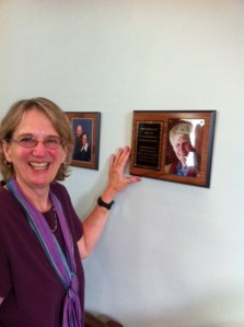 Kristen Jarvi in front of the plaque honoring her mom, Betty Jarvi. Other plaques not visible are honoring Jane & Rob Buswell & Evelyn Warren. Photo by Annie Clarke.